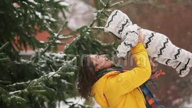 宝宝在妈妈怀里散步.. 冬天走在雪地下的公园里。 妈妈把宝宝抱起来，宝宝看起来